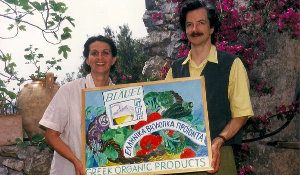 KI generiert: Zwei Personen halten ein Schild mit der Aufschrift "BLAUEL GREEK ORGANIC PRODUCTS".
