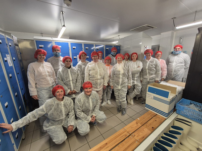 Eine Gruppe Besucher mit hygienischen Schutzanzügen in einem Umkleideraum.