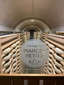 Blick in das Reifelager mit großen Käselaiben in den Reiferegalen.