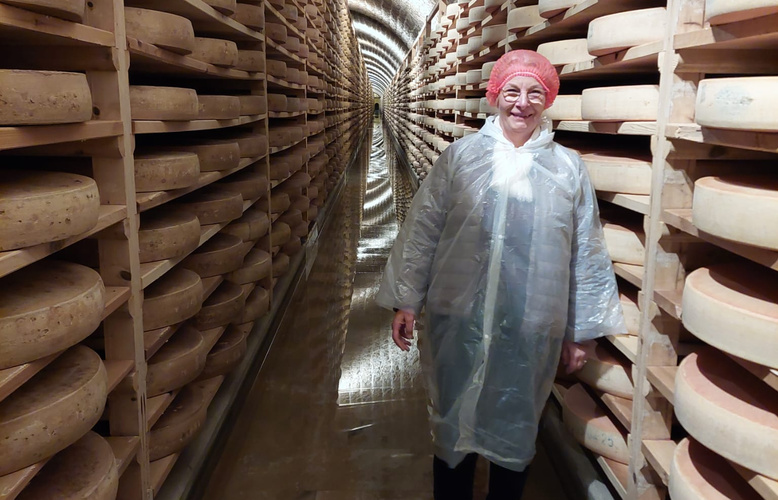 Katrin steht im Reifekeller vor Käselaiben.