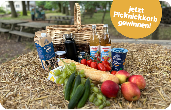 KI generiert: Picknickkorb mit Bio-Lebensmitteln auf Heu. Text: "jetzt Picknickkorb gewinnen!".