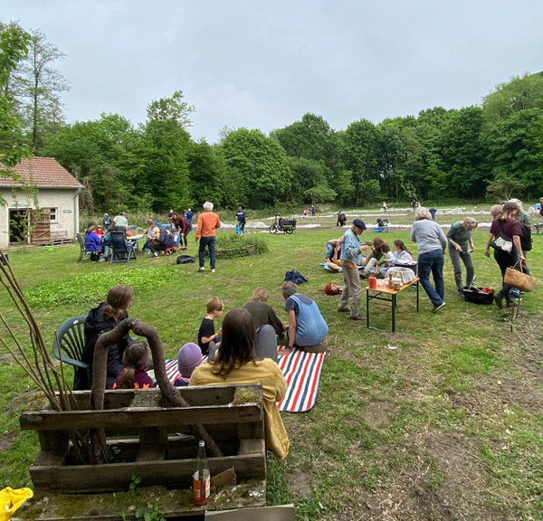 Katrin greift bei einer Käseverkostung zu einem Stück Käse und hat eine passende Weinbegleitung in der Hand.