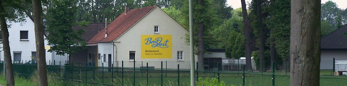 KI generiert: Ein Gebäude im Grünen mit einem Schild: "BrotZeit Bäckerei Marian Broich".