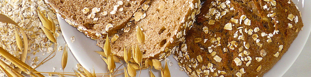 KI generiert: Vollkornbrot mit Haferflocken auf einem Teller, dekoriert mit Haferähren.