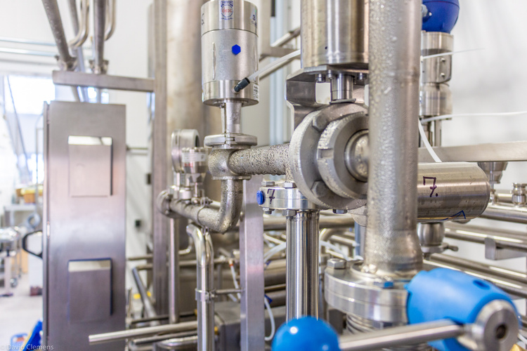 KI generiert: Industrielle Rohrleitungen und Ventile in einer Fabrikumgebung.