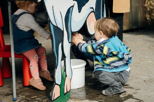 KI generiert: Zwei Kinder sitzen auf einem grünen Roller und lächeln.