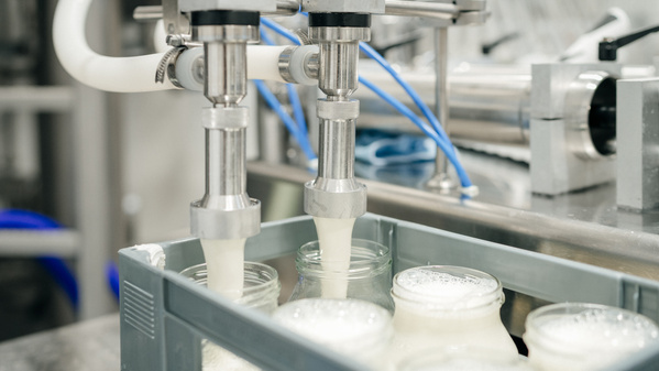 KI generiert: Abfüllung von Milchflaschen in einer Fabrik mit moderner Anlage.