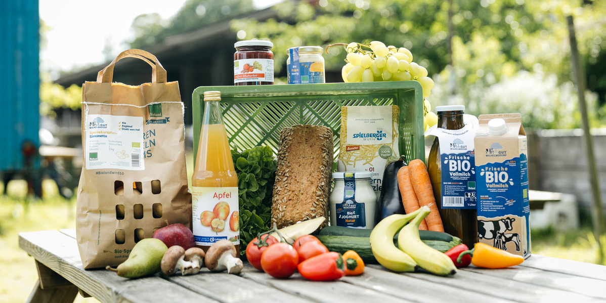 KI generiert: Verschiedene Bio-Lebensmittel auf einem Tisch, darunter Obst, Gemüse und Getränke.