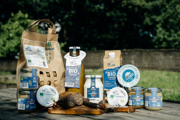 KI generiert: Eine Auswahl von Bio-Produkten präsentiert auf einem Tisch im Freien.