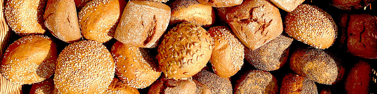 KI generiert: Eine Vielzahl von Brötchen, einige mit Sesam und Mohn bestreut.