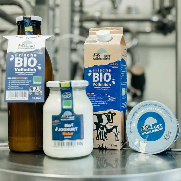 KI generiert: Bio-Milchprodukte von "Gut Wilhelmsdorf", darunter Vollmilch und Joghurt auf einem Tisch.