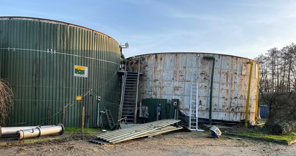 KI generiert: Zwei große Biogastanks mit Schildern und Umgebung, darunter Baugerüst und Rohrleitungen. Text: "BIOGAS".