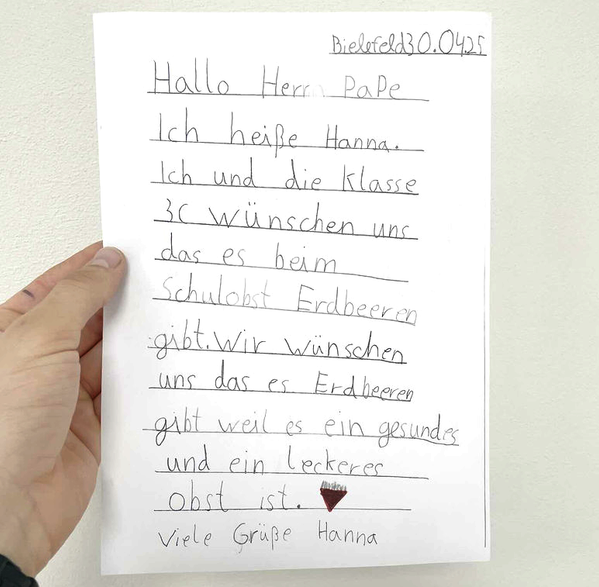KI generiert: Ein handgeschriebener Brief von Hanna mit dem Wunsch nach Erdbeeren im Schulobst.