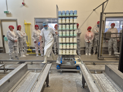 Besuchergruppe in einer Käserei.